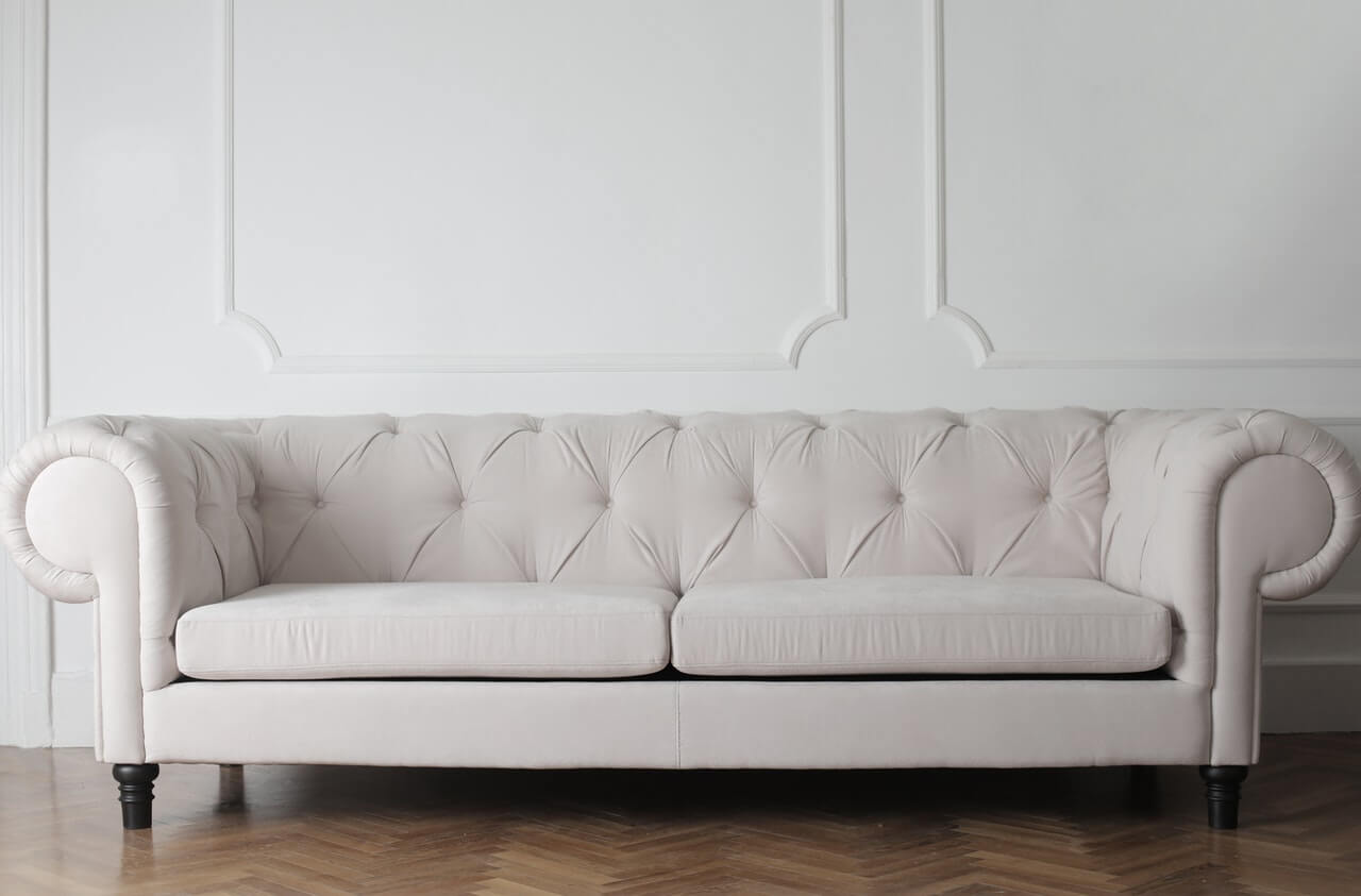 sofa capitone clasico patas madera tapizado