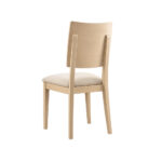 Silla ELSA tapizada con respaldo curvo y estructura de madera de haya, fabricada en España.
