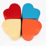 Puf tapizado Lubov modular con forma de corazón, combinable por unidades, disponible en varios tejidos, ideal para oficinas y hoteles, fabricado en España.