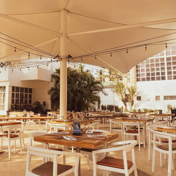 Espacio de restauración exterior equipado con mesas y sillas para hostelería de diseño moderno.